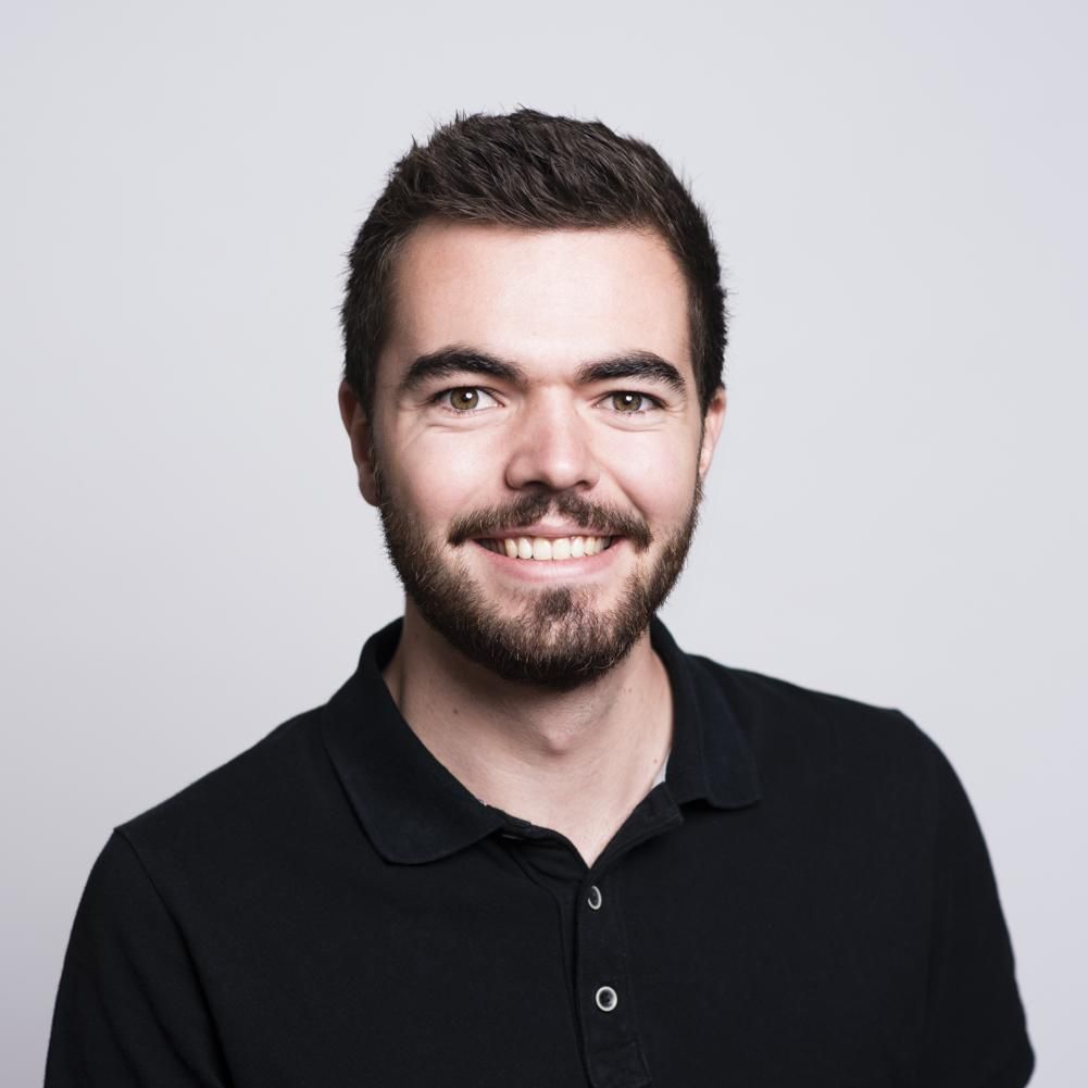 A professional head shot of the author with plain background